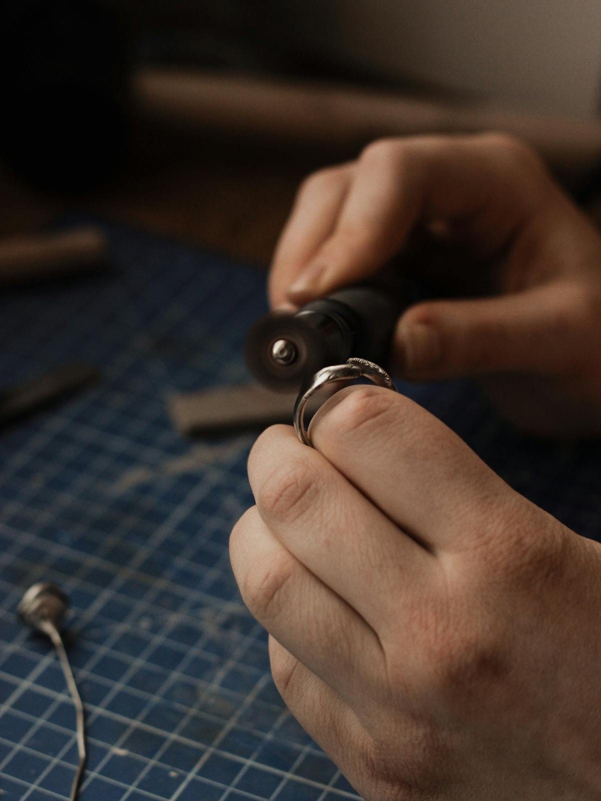 Craftsman using rotary tool to polish and engrave