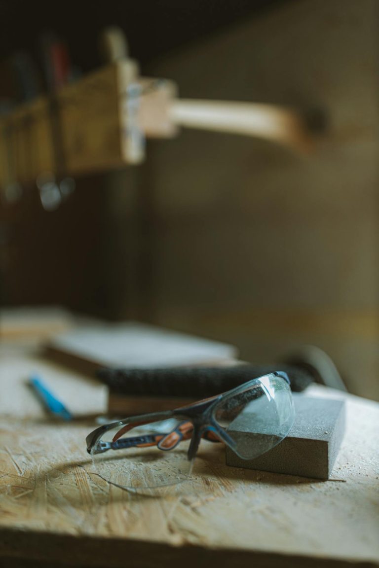 Safety goggles and tools on workbench in workshop