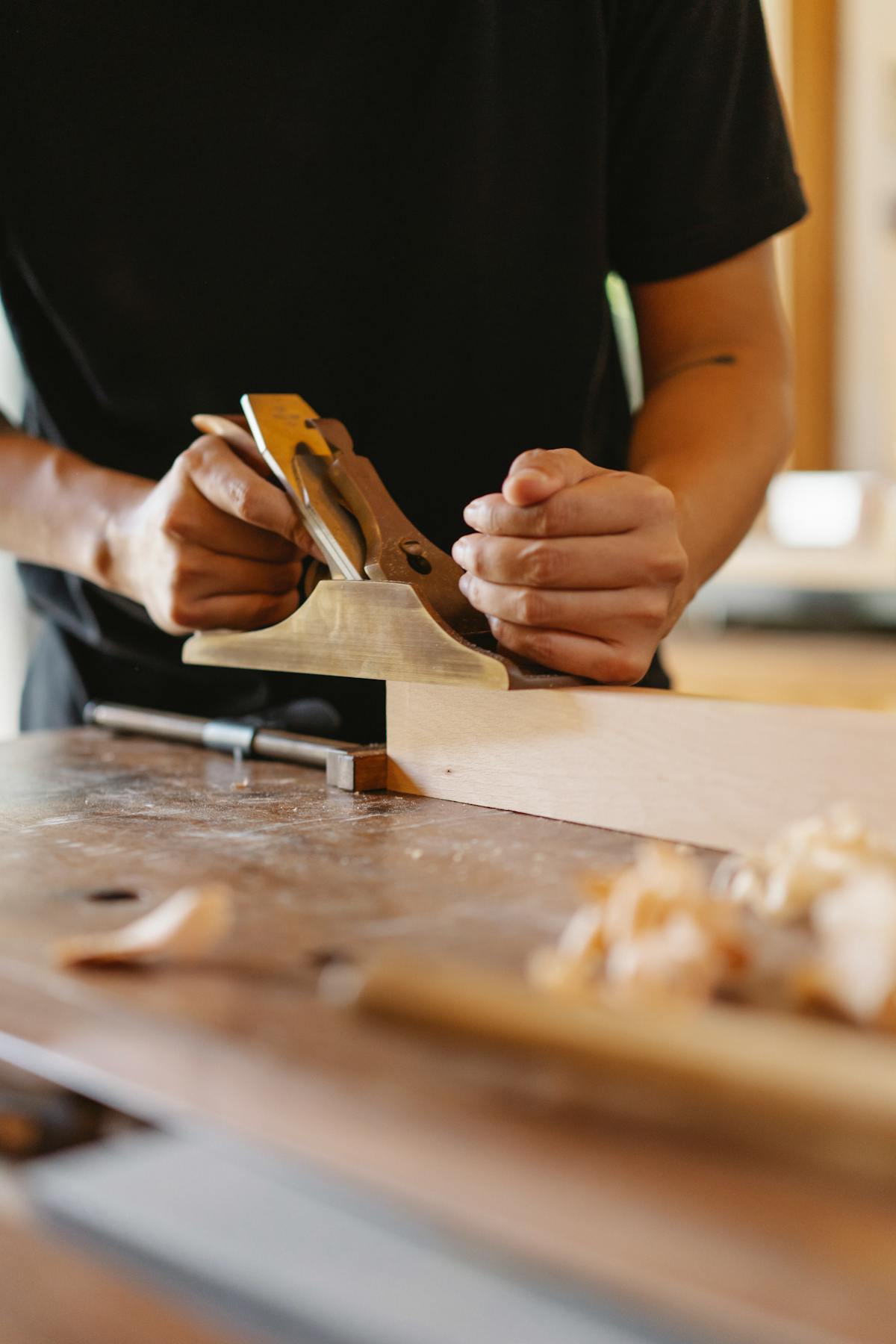 Woodworker using a benchtop planer in a workshop