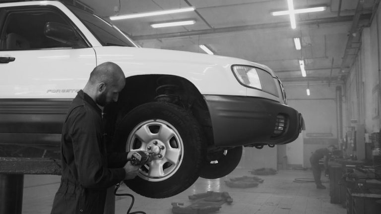 Mechanic using impact wrench on car tire