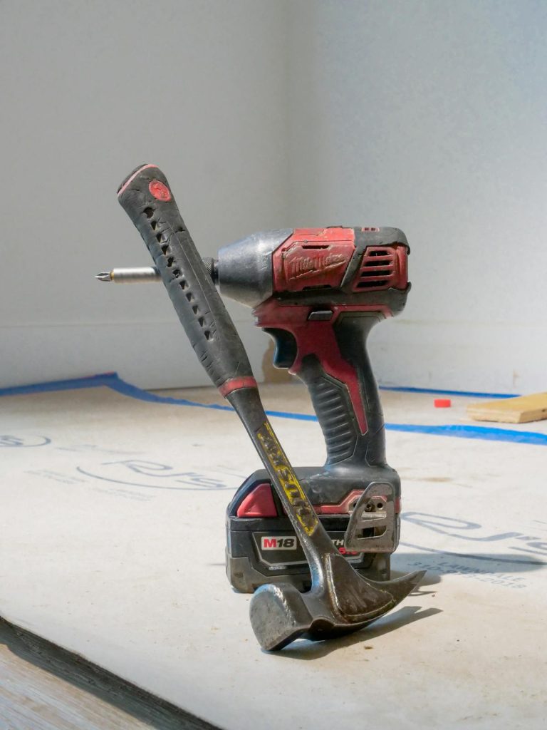 Red power drill and hammer on construction site