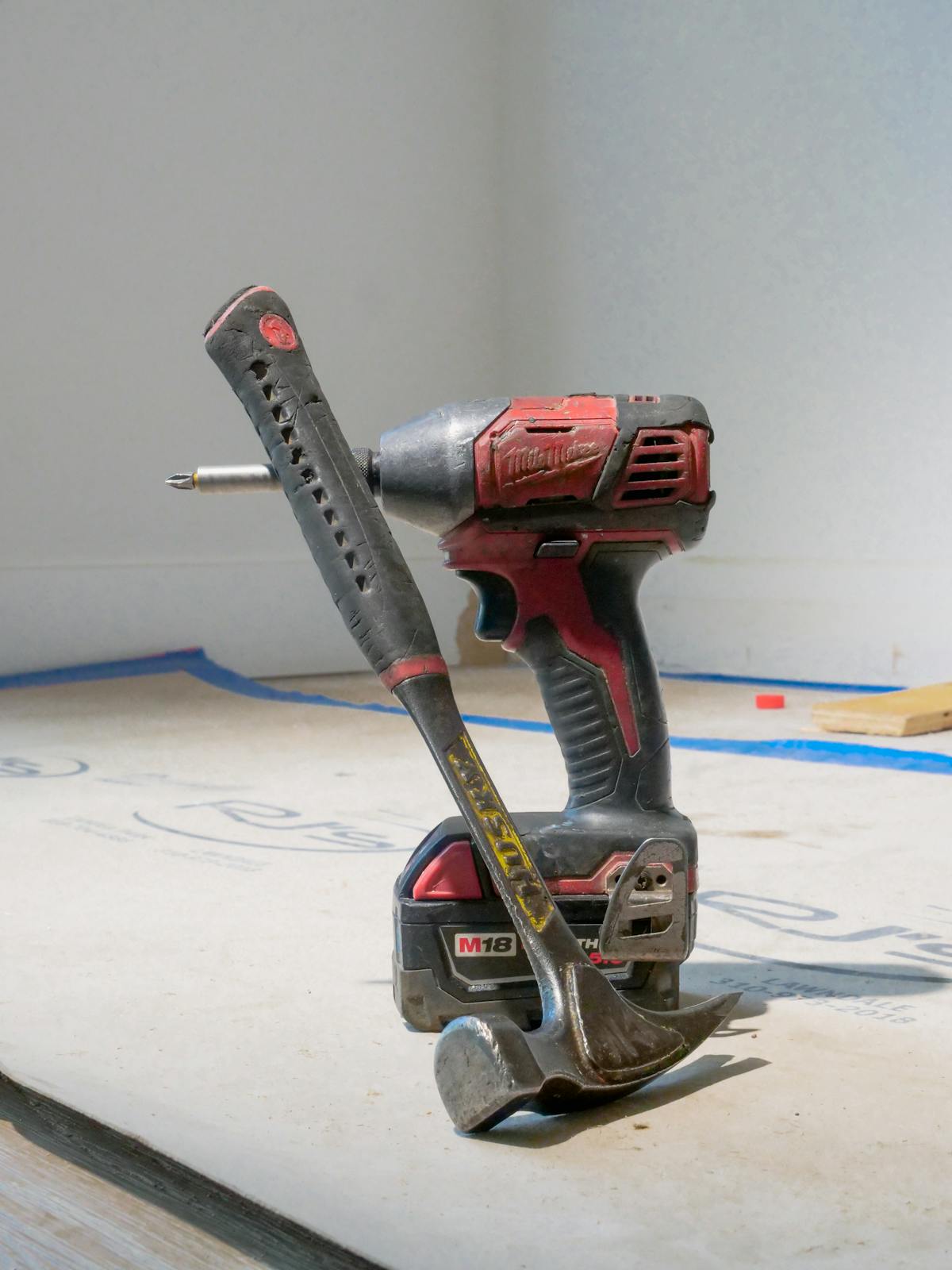 Red power drill and hammer on construction site