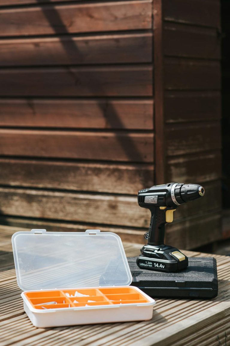 Cordless drill and accessories on wooden surface