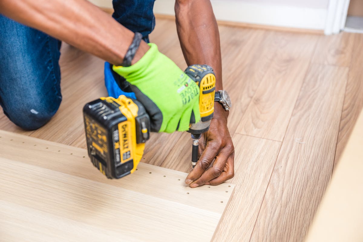 Handyman drilling wood with green cordless power tool